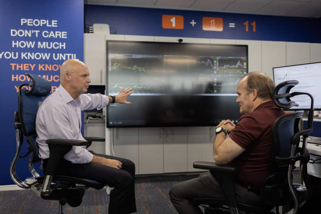 Members of the Atlas Oil Supply and Marketing team look at current market trends on a large screen.